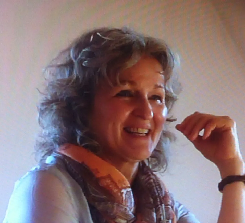 Martina Ahlborn lacht, mit lockigem Haar und buntem Schal.